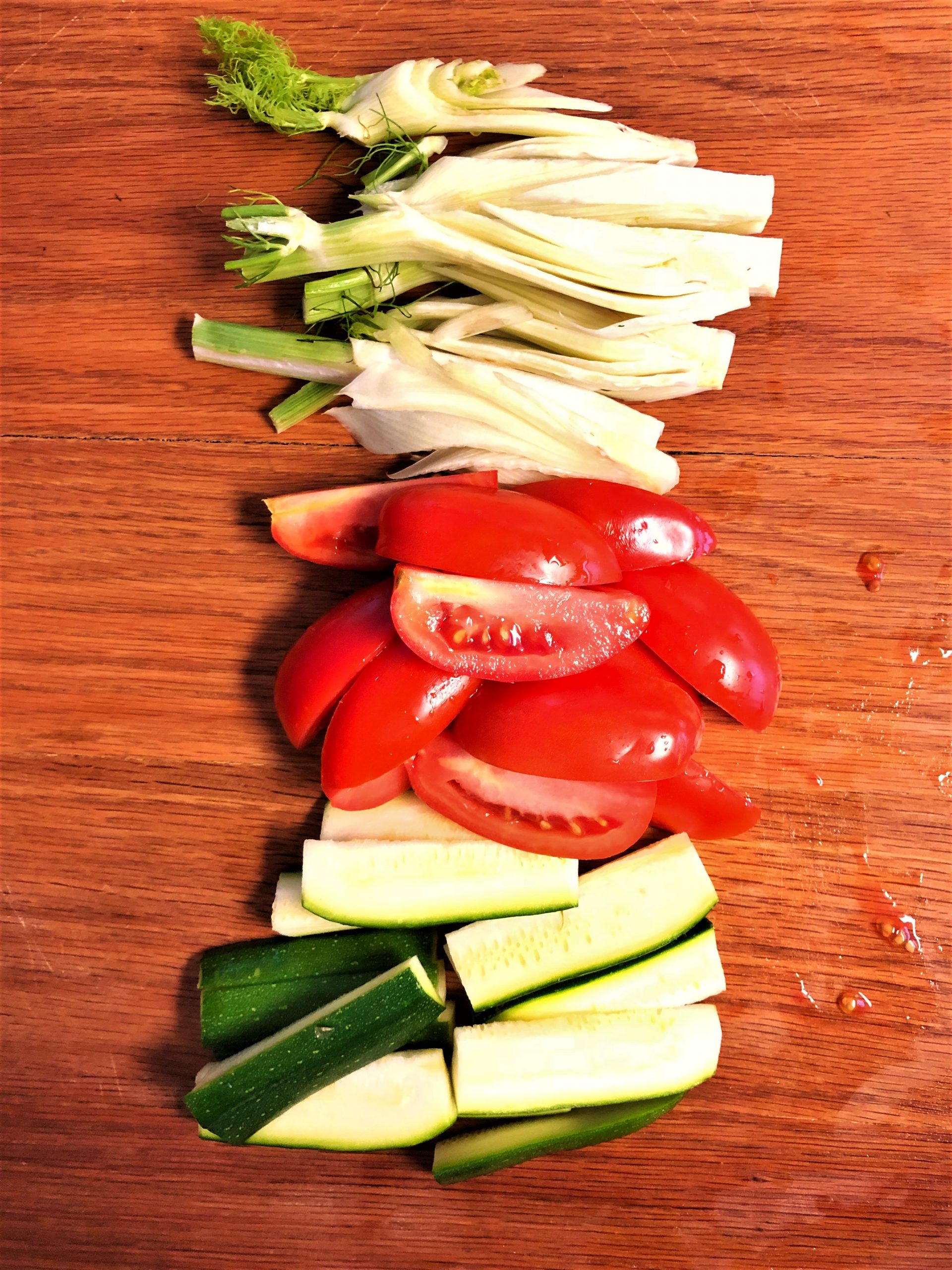 sliced fennel, tomatoes and zucchini on a cutting board