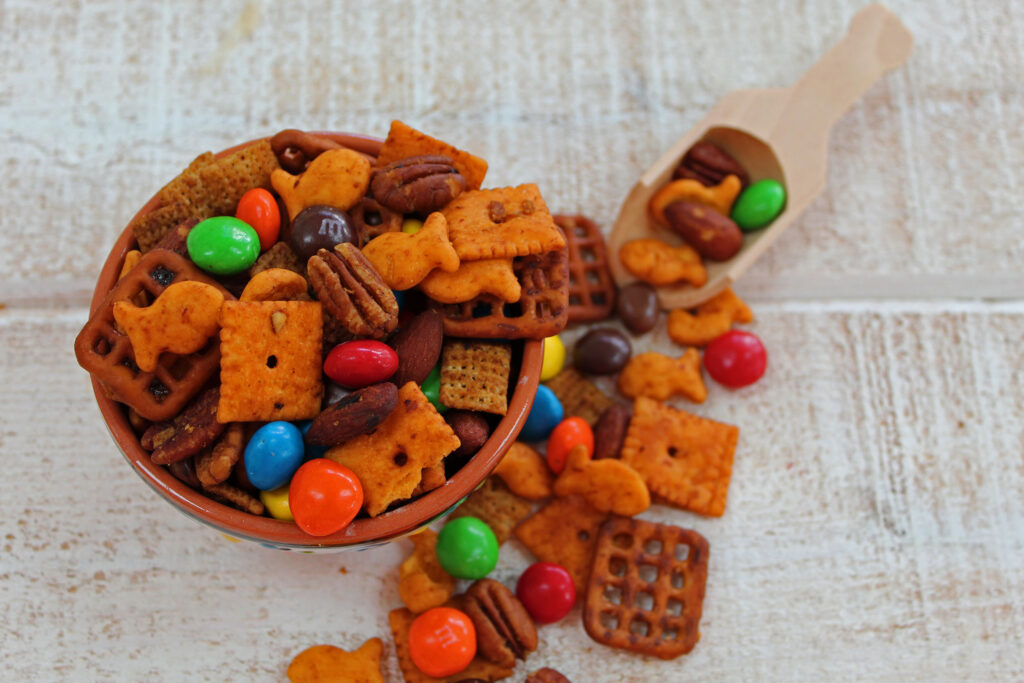 trail mix in a little bowl with a wooden scoop